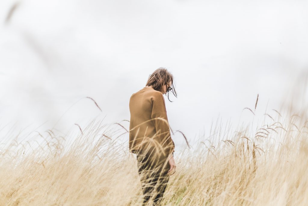 Woman feeling alone in a sea of grass.