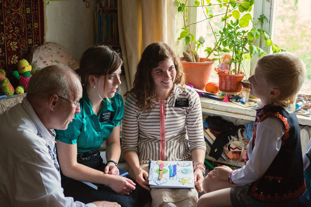 Sister missionaries teaching a boy