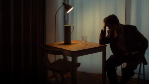 man in with head resting on hand