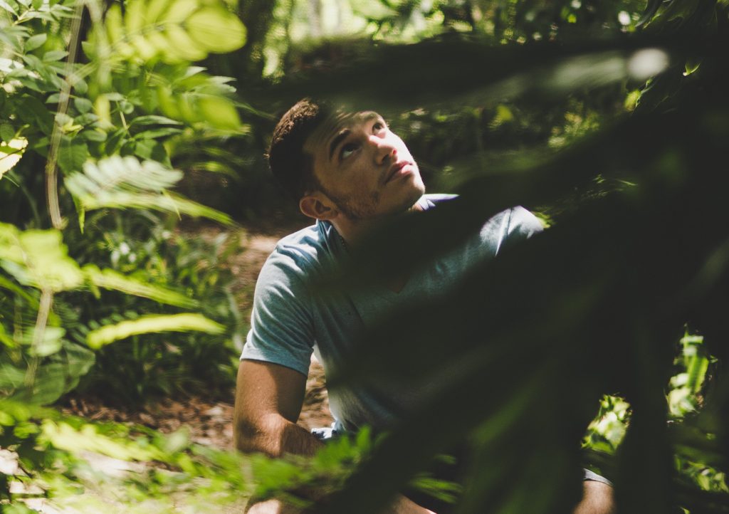 man in woods looking up