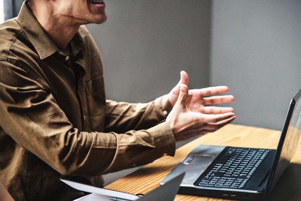 man shouting in front of laptop