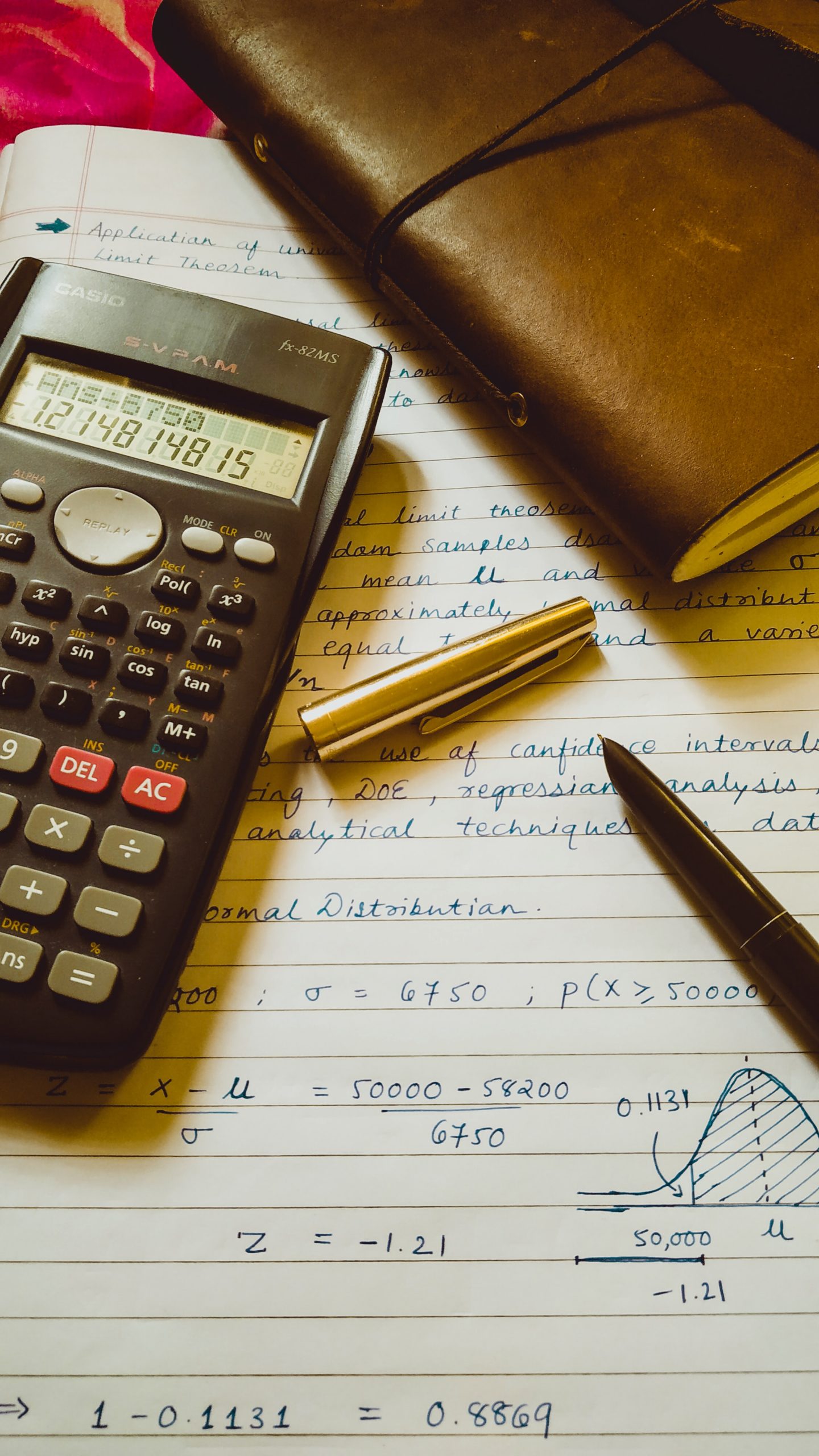 calculator, pen and notebook on paper