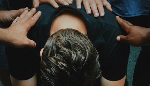 A struggling man surrounded by family and friends